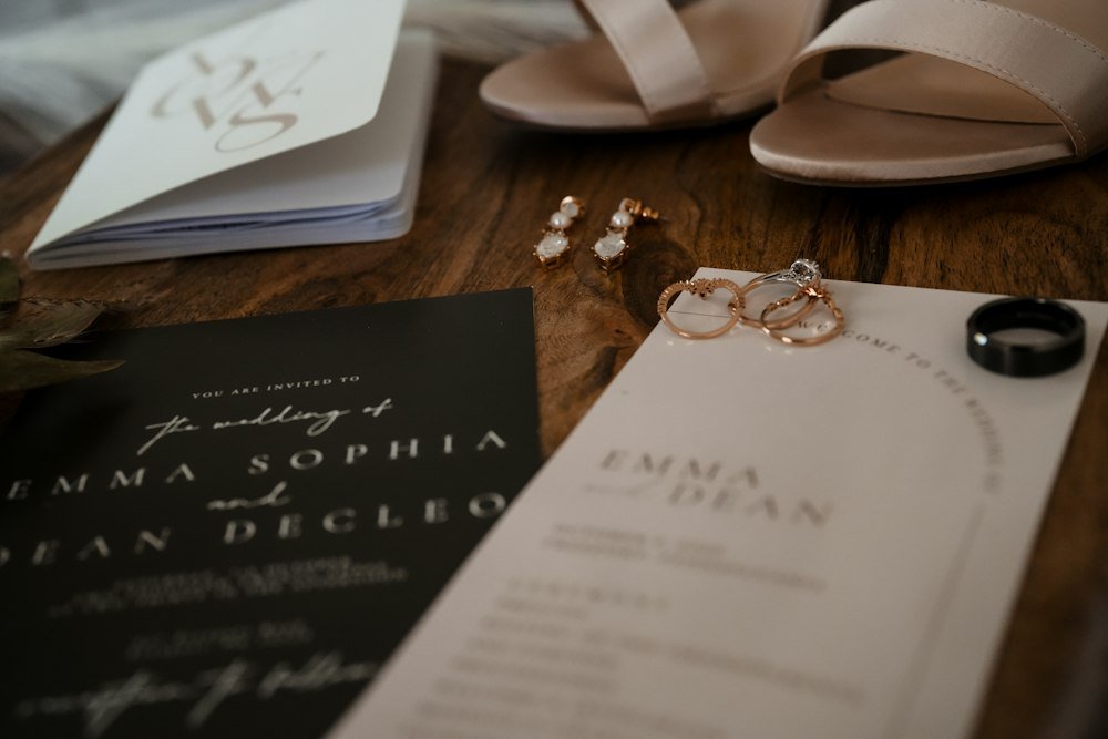 Wedding rings resting beside a printed invitation